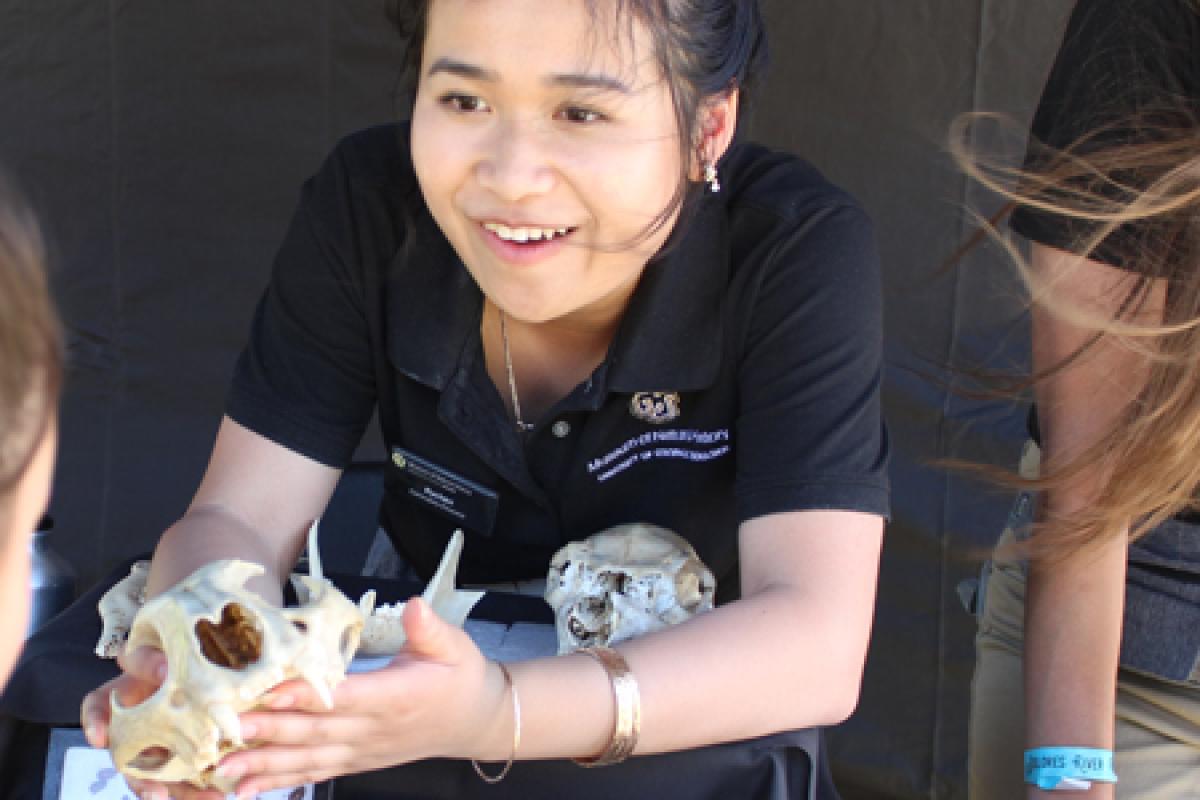 college student showing skull to young child