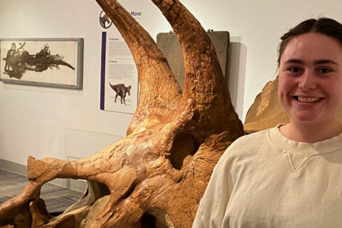 Sunny Smith standing in front of triceratops skull in Paleontology Hall