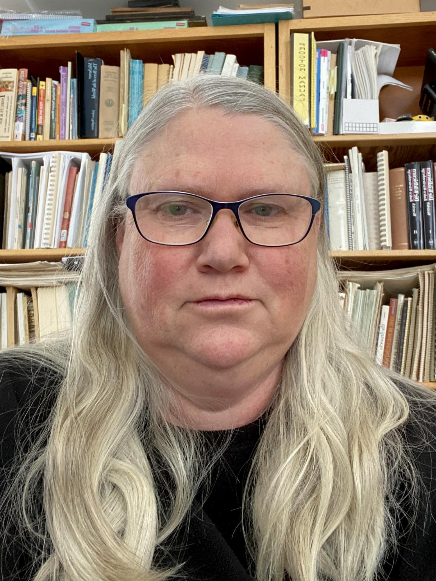 Headshot of Virginia Scott in front of library shelves