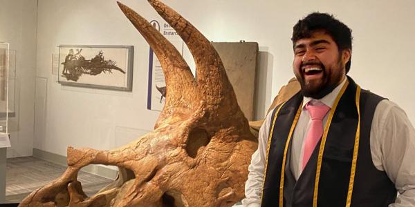 Jose standing in front of triceratops skull in Paleontology Hall