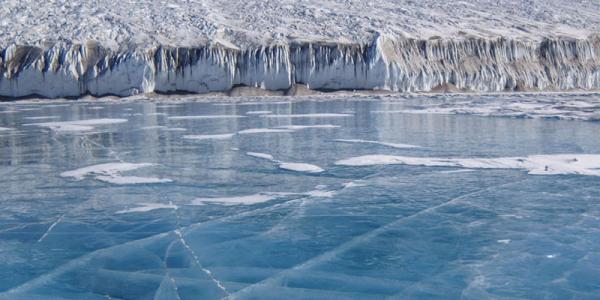 bight blue frozen lake with cracks in ice