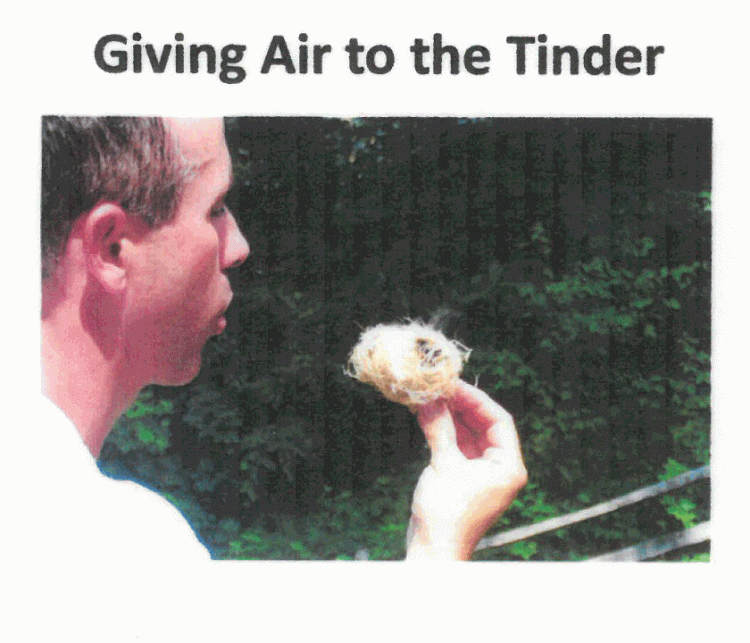 man blowing air on tinder