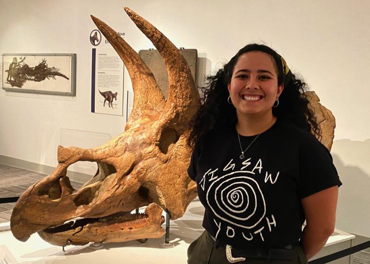 Hope Fox standing in front of triceratops skull in Paleontology Hall