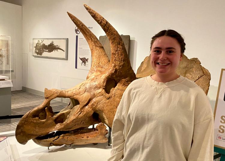 Sunny Smith in front of triceratops skull in paleontology hall