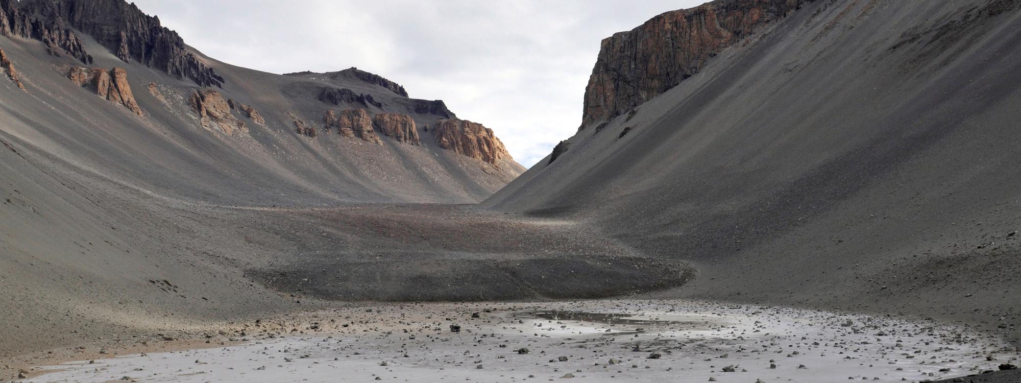 Dry valley with sandy brown dirt and brown mountains