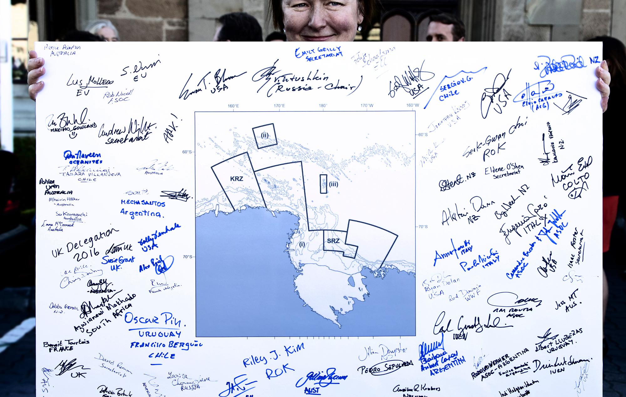 Woman holding map of Marine Protected Area with signatures on it.