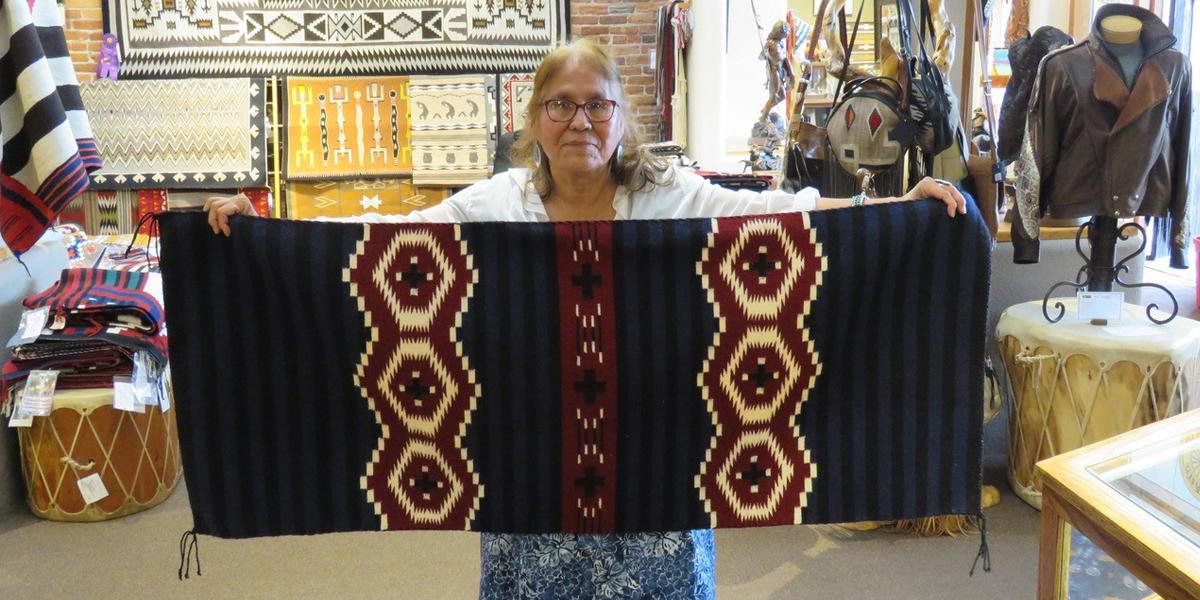 Woman holding rug with geometric patterns