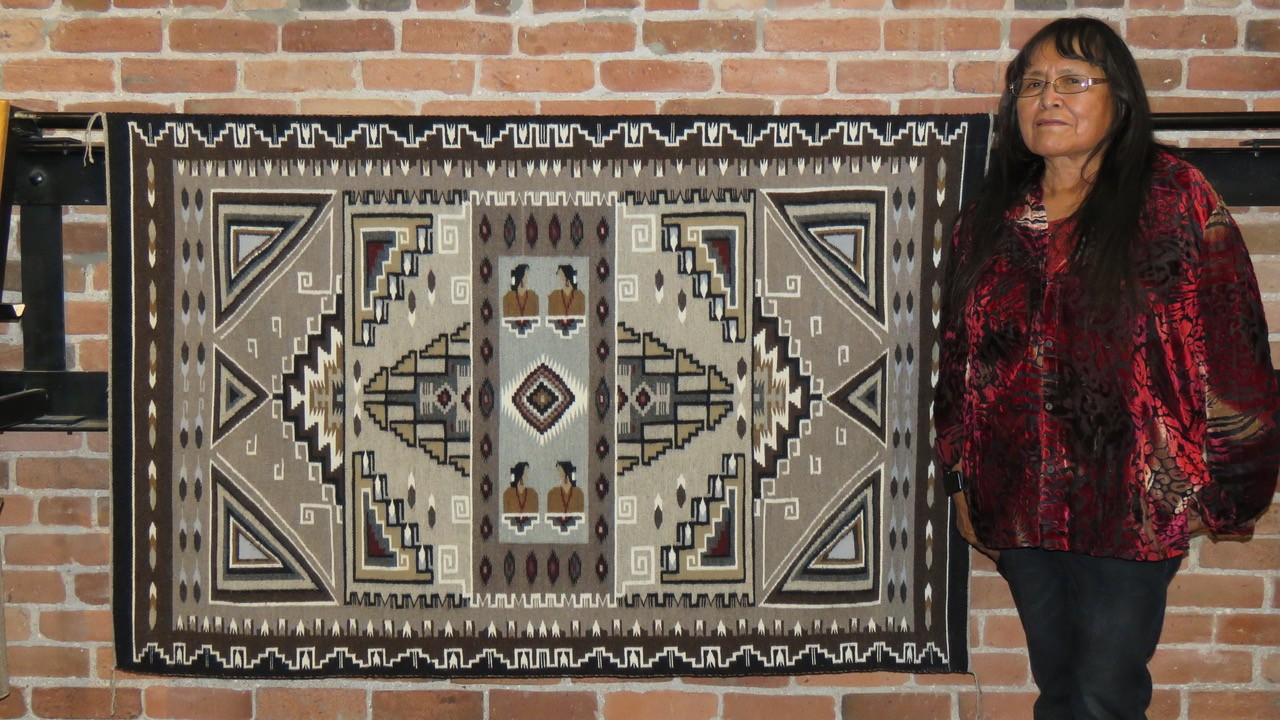 woman standing next to rug with geometric patterns
