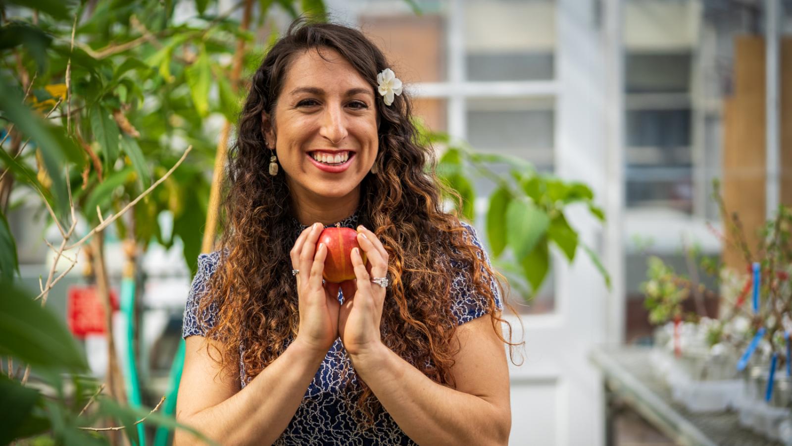 woman holding apple and smiling