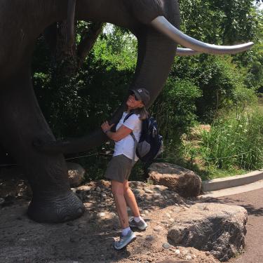 Barbara Diehl hugging the leg of a large elephant sculpture