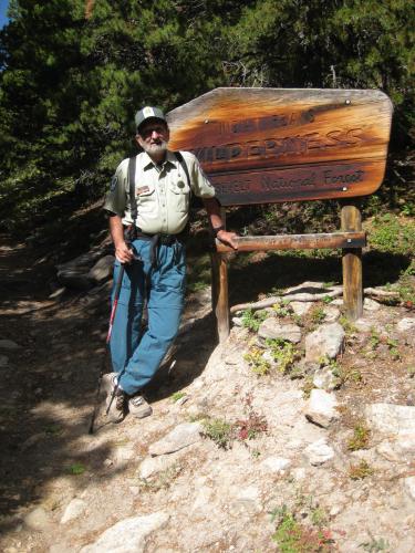 Robert Pudim standing in front of Indian Peaks Wilderness sign