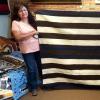 Two Navajo women holding blanket in textile shop