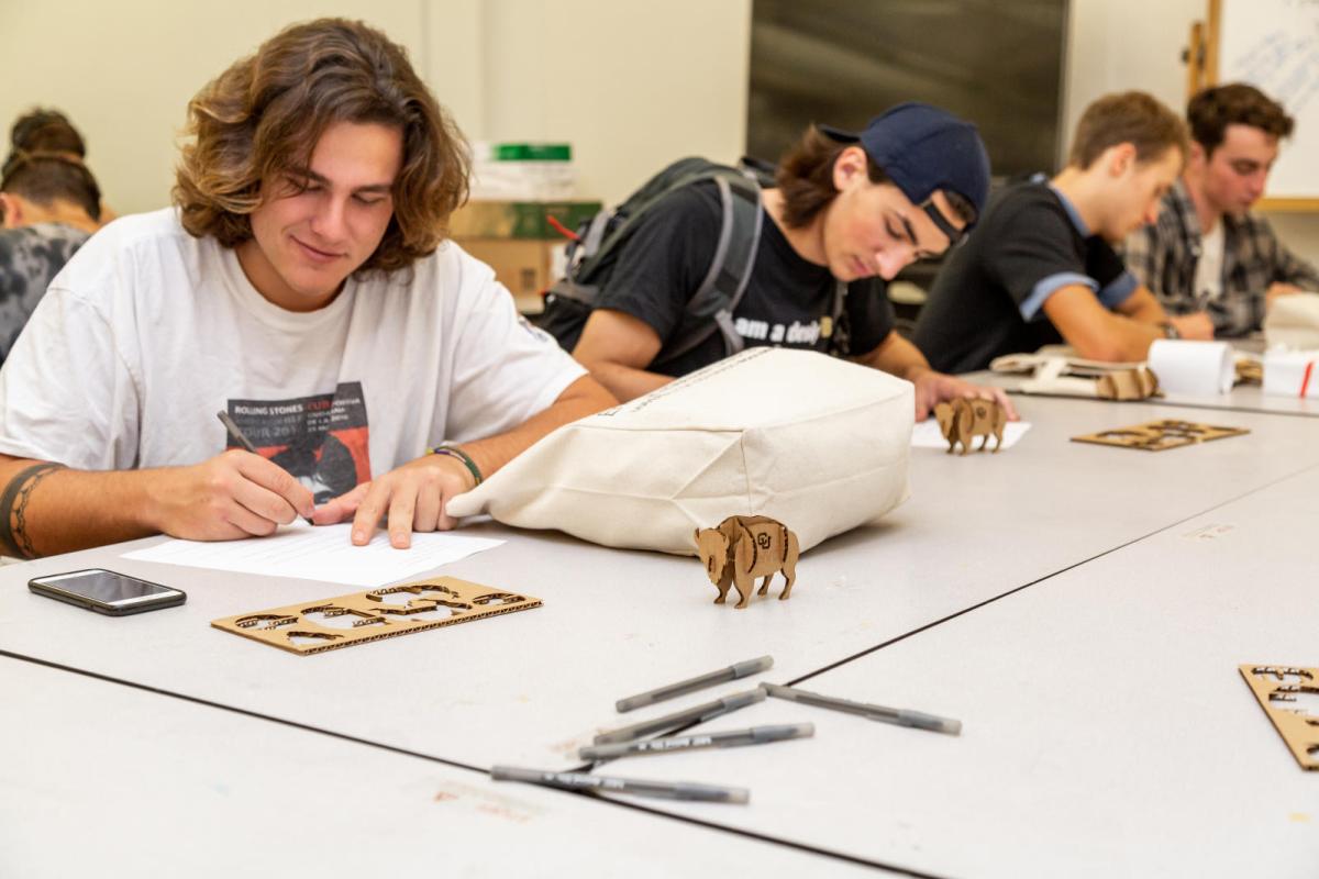 students working at a table in a classroom