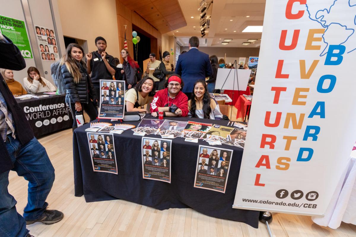 students sitting at a table that says cultural events board