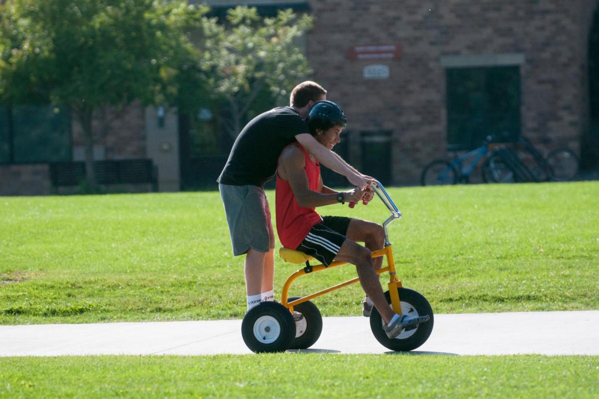 two students on a tricycle