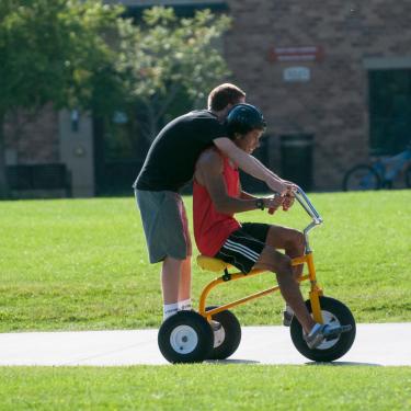 two students on a tricycle