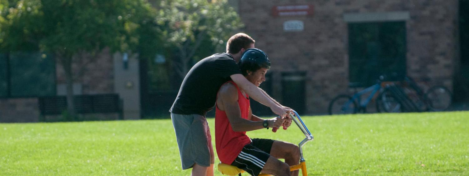 two students on a tricycle