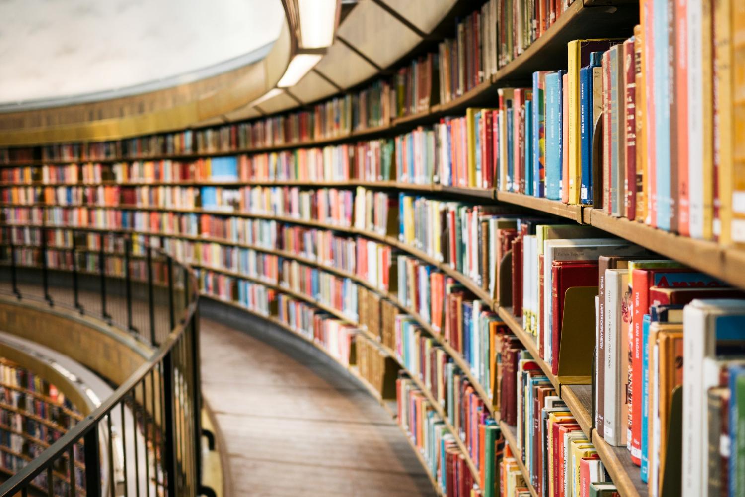 A curved bookcase filled with hundreds of books
