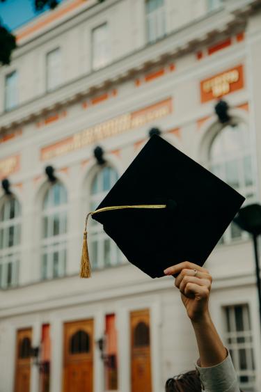 A student holding up a graduation cap