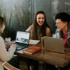 People sitting around a table looking at a laptop computer