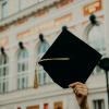 A student holding up a graduation cap