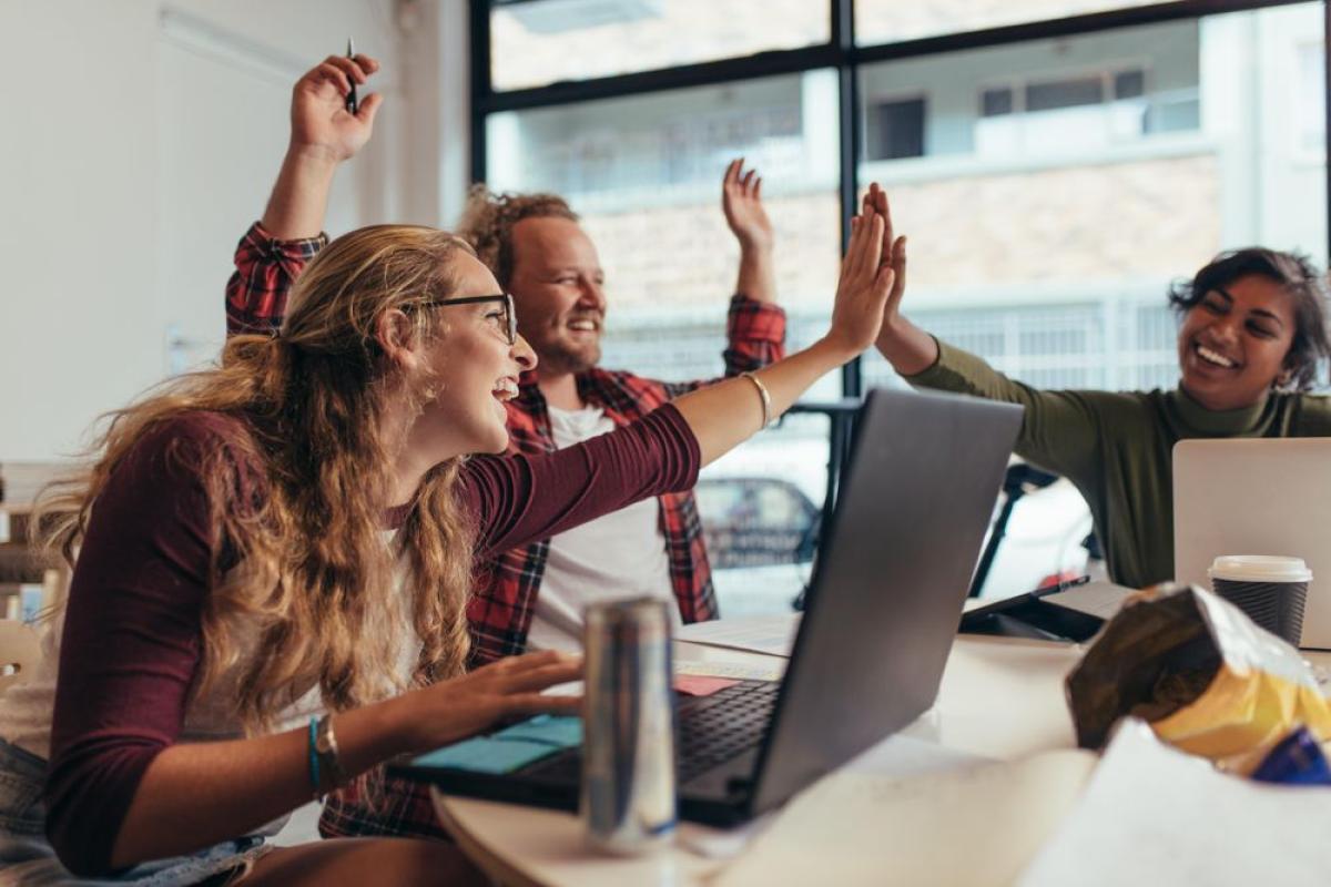 Cheerful startup business team rejoicing success at office