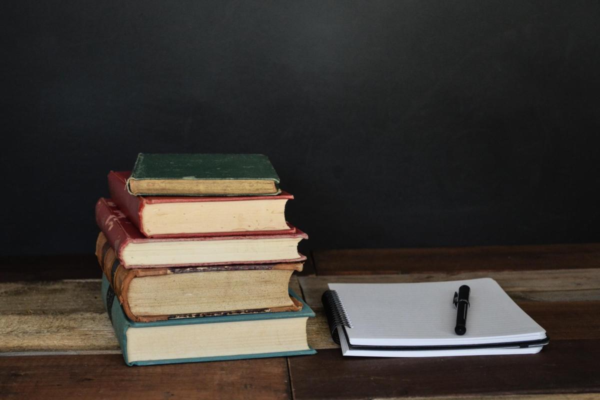 books sitting beside a notebook