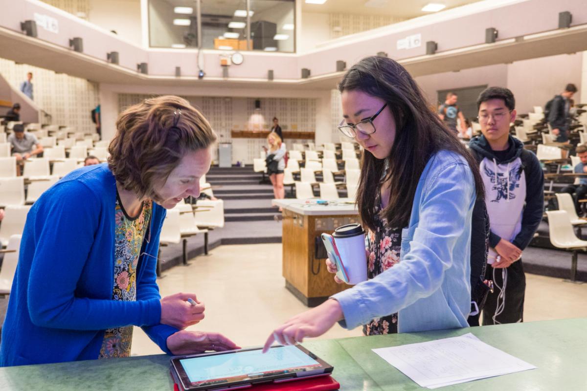 Photo of a faculty member talking with a student after class.