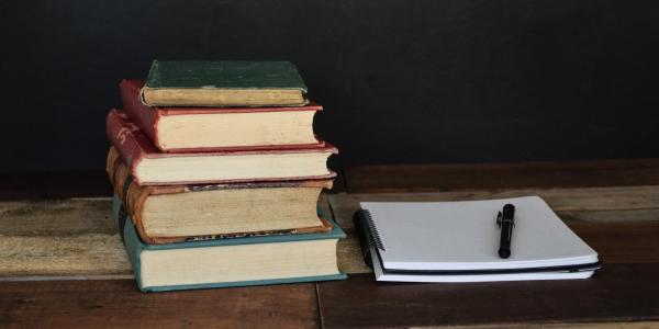 books sitting beside a notebook