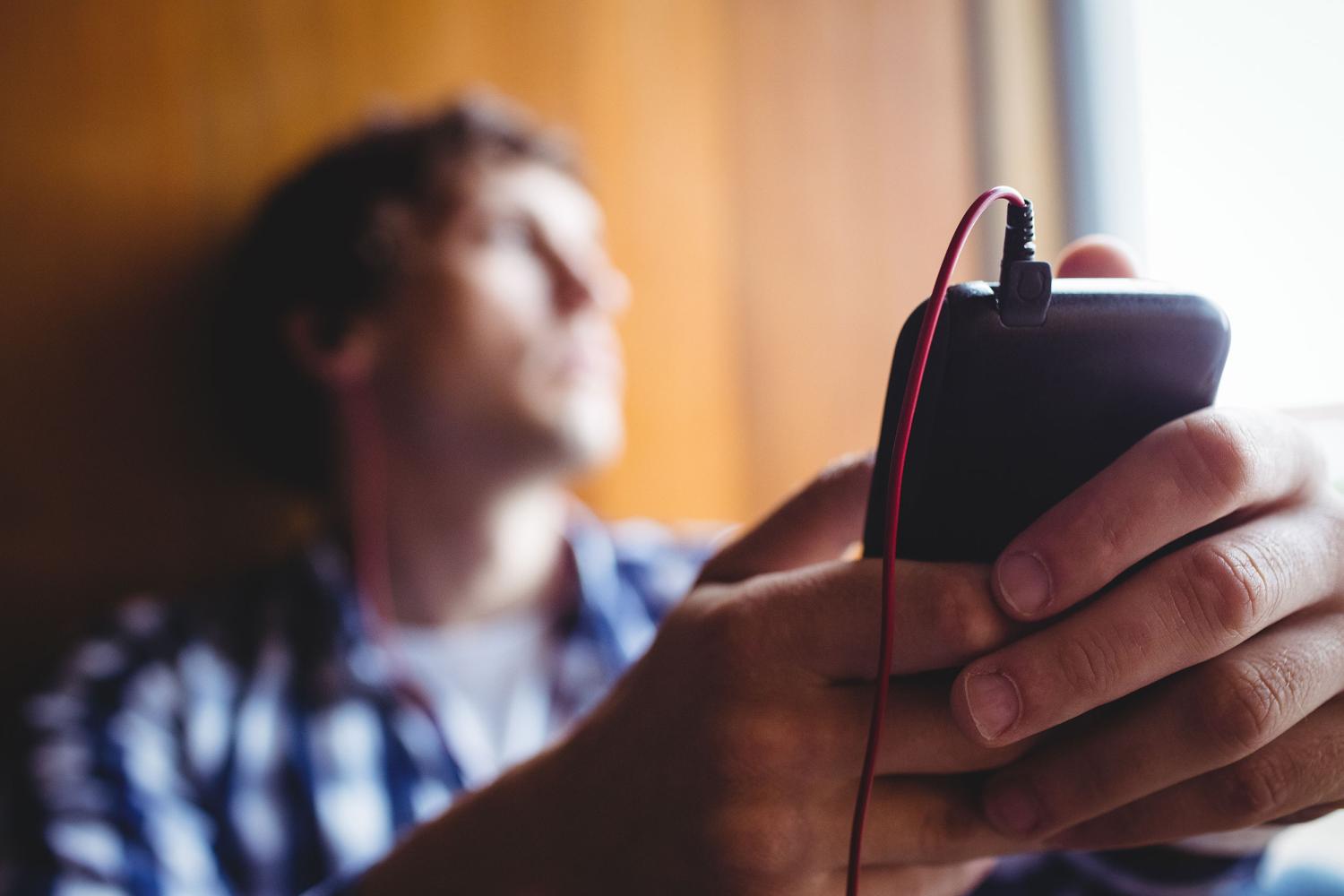 Man leaning on wall listening to phone