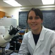 Alix in the lab using a microscope to study bacteria