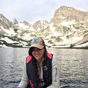 Loria smiles in front of a chilly alpine lake.