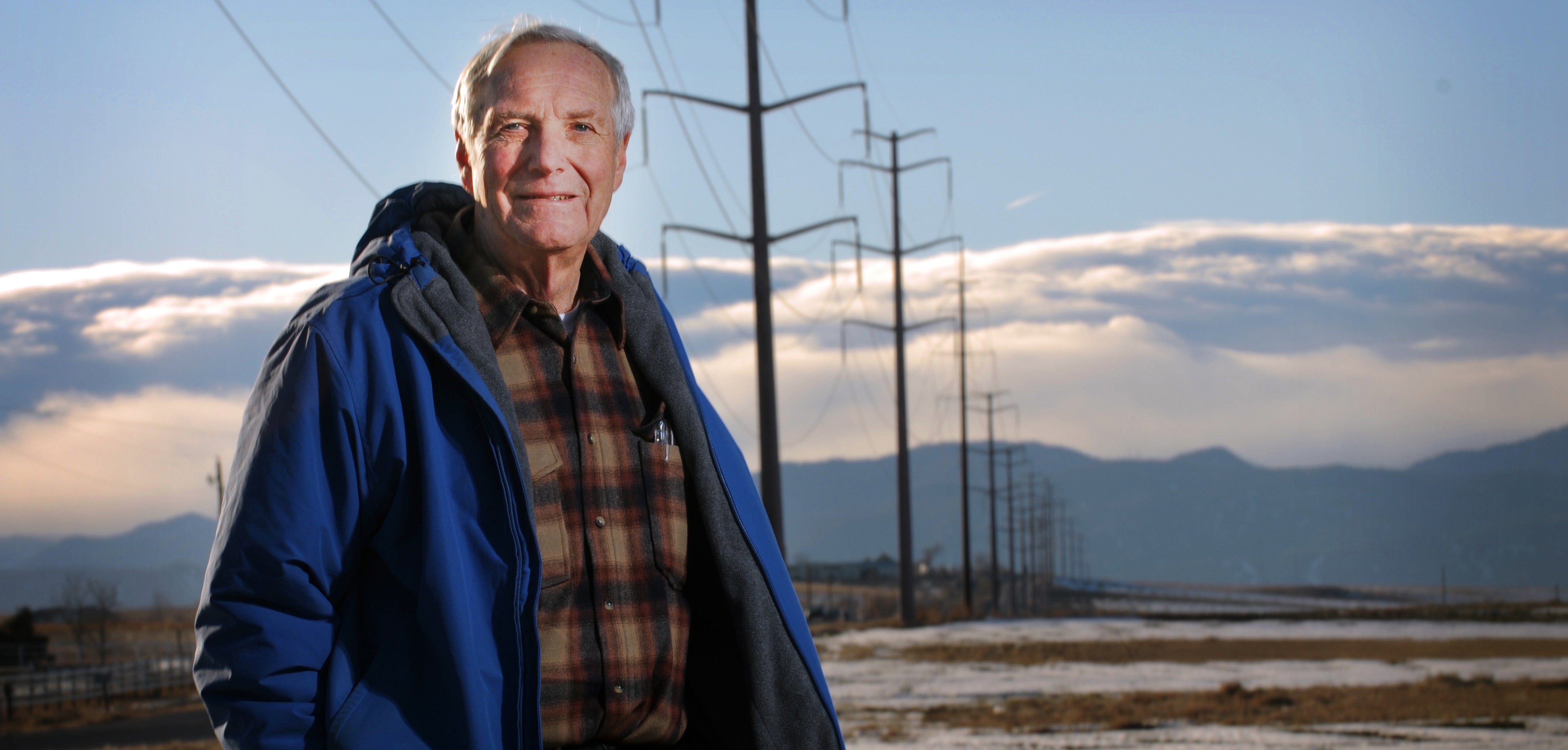 Barnes in a field with power lines in the distance, for a story on his research in 2010