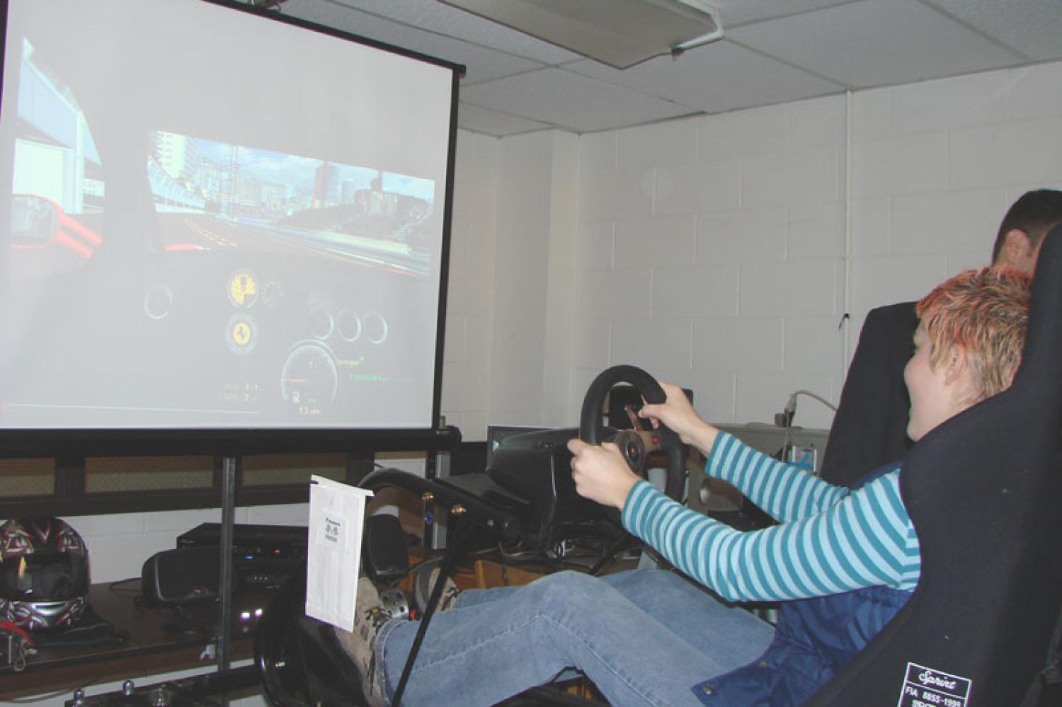 A guest tries out RIDE's virtual racing vehicle cockpit during the capstone expo.