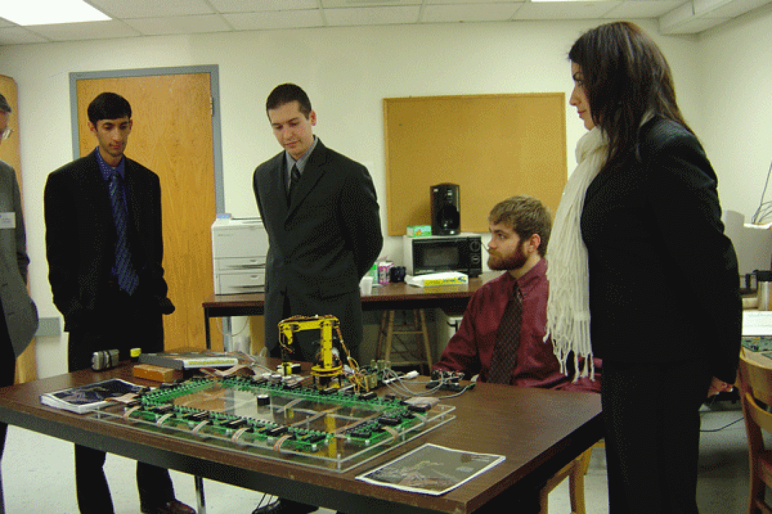 The four members of Strongarm demonstrate their project at the expo