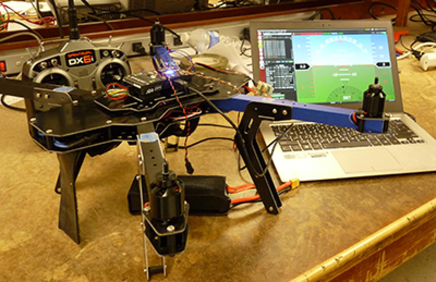 The UAV Pals quadcopter sits beside a laptop showing the control interface