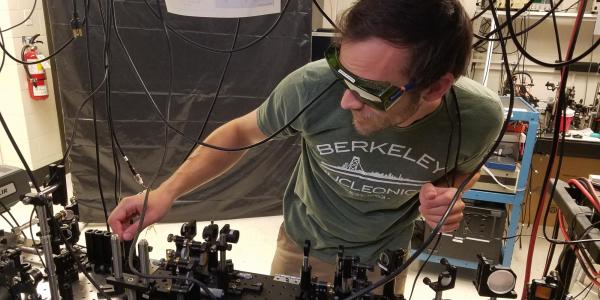 Brendan Heffernan adjusts optical components at a light table in the team's lab. 