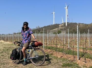 Nikhar Abbas cycling by wind turbines.