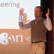 Rob Streeter discusses his presentation with emcee Bud Coleman at the 3MT finals
