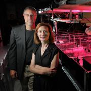 Physics professors Margaret Murnane and Henry Kapteyn of JILA pose next to one of the laser apparatuses in their lab at the University of Colorado Boulder campus. 