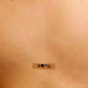 The Band-Aid-sized sensor mounted on a chest to measure heart rate.