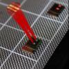 A silicon chip with a tiled array of serpentine optical phased array (SOPA) tiles. Drawn superimposed are beams from two matching tiles and the far field beam interference pattern demonstrating tiled beam forming.