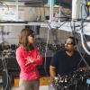 Juliet Gopinath and a grad student discuss a project at the optical table in their lab