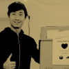 Moon gives a thumbs-up next to a box of masks waiting to be shipped