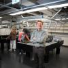 Diddams in front of optical tables where students are at work on projects