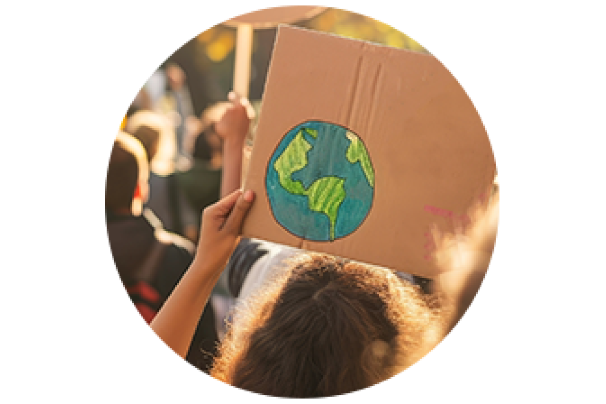A person holding a sign with a drawing of earth
