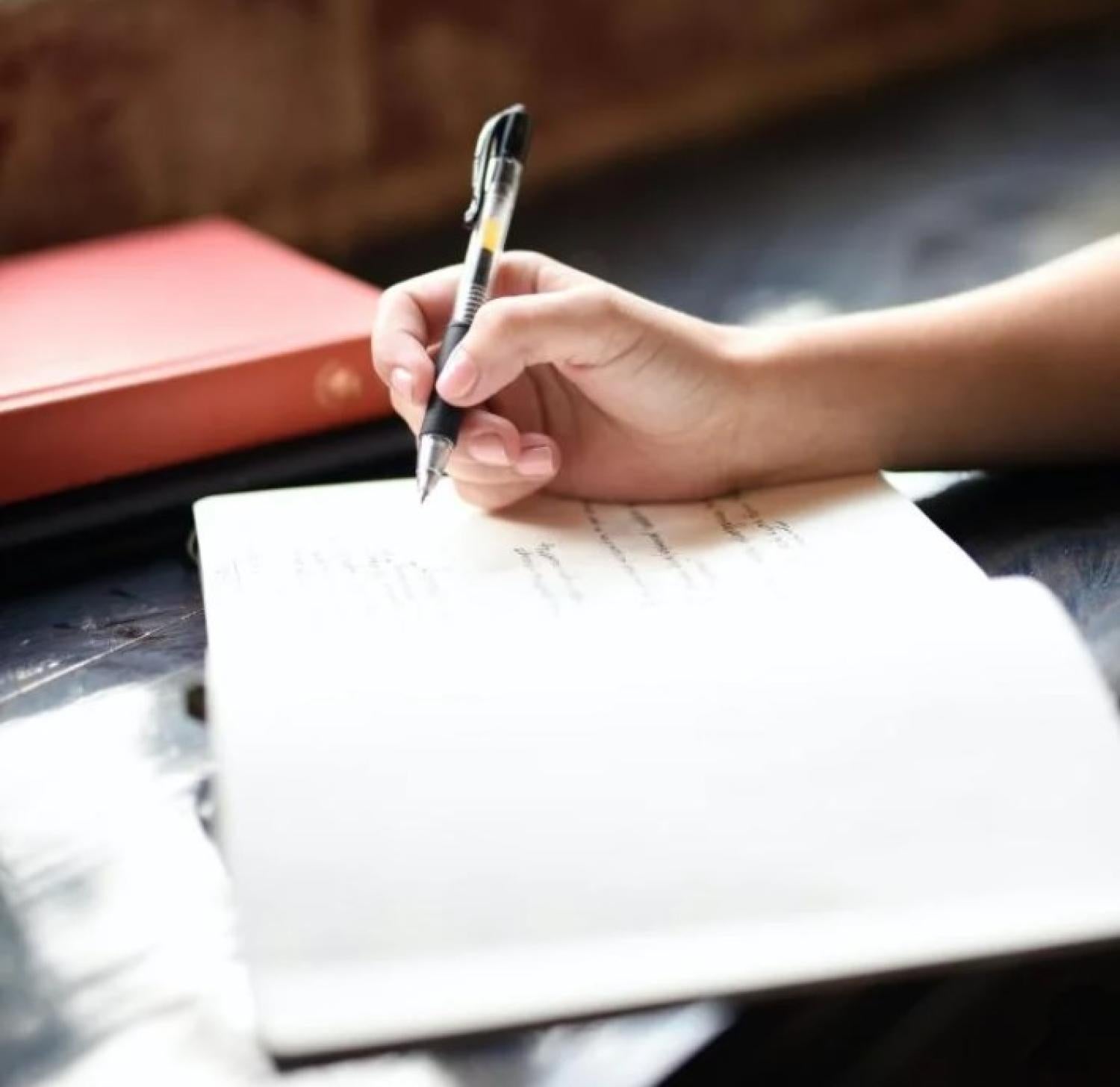 student writing in a notebook
