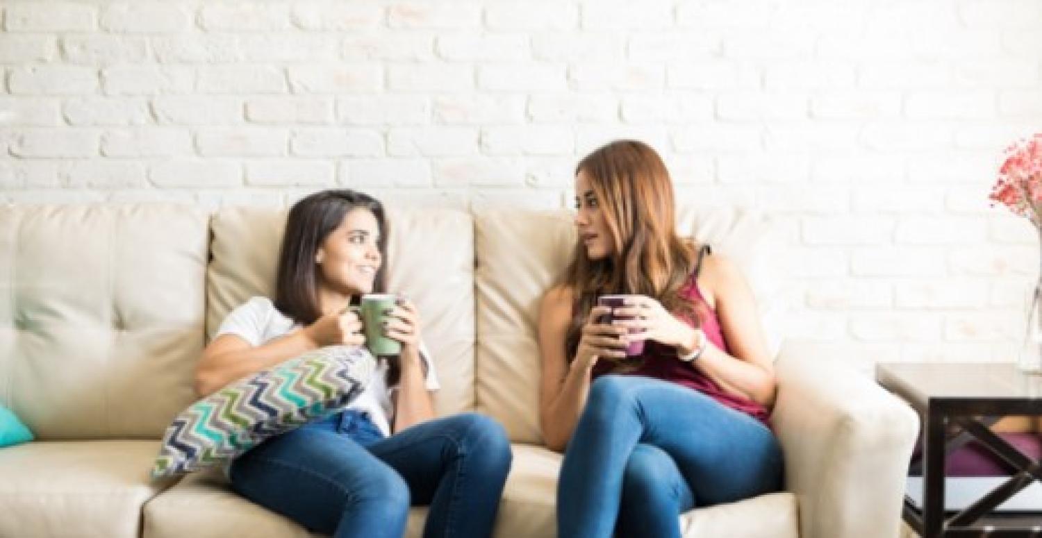 two women talking on a couch