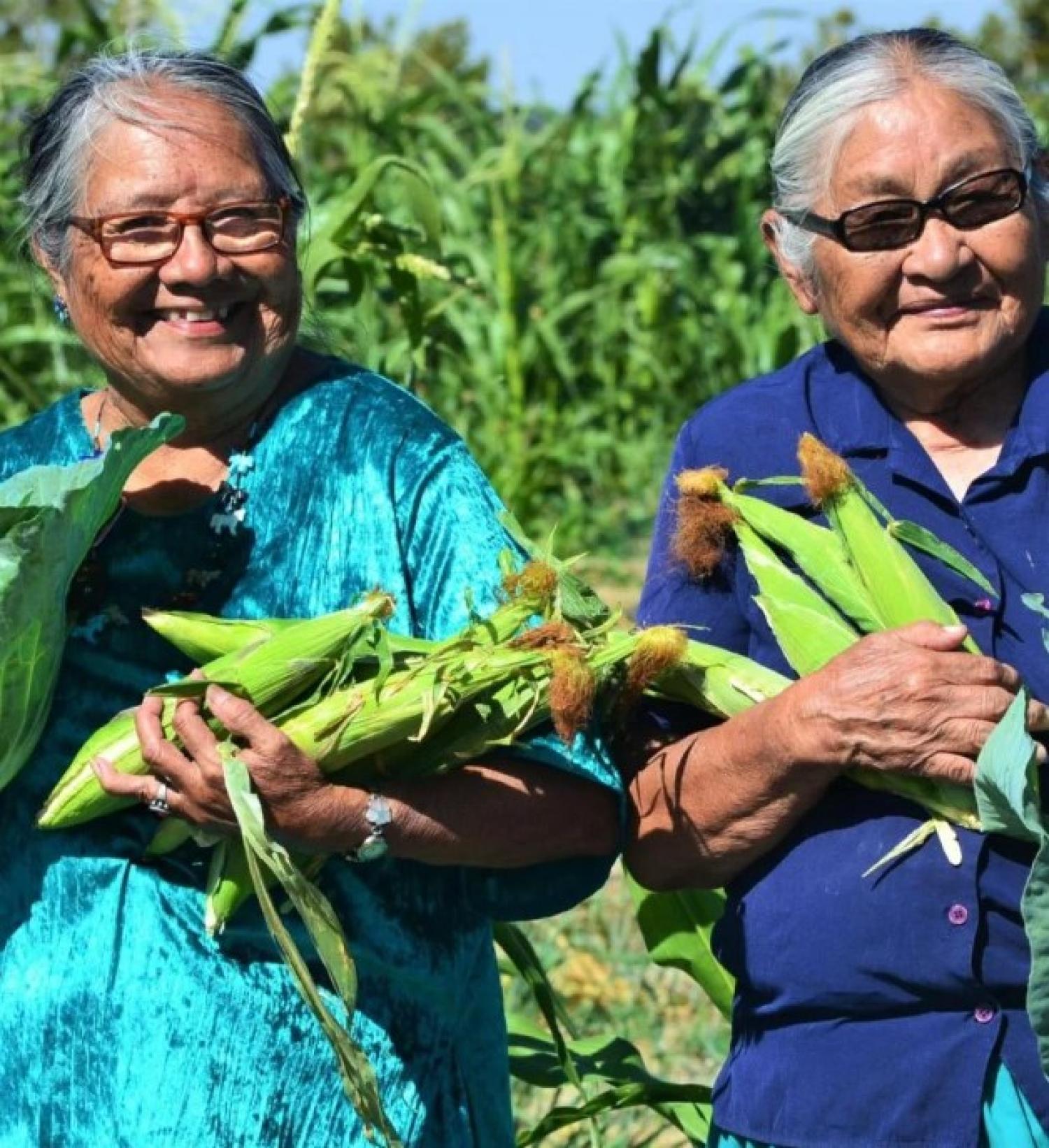women carrying corn