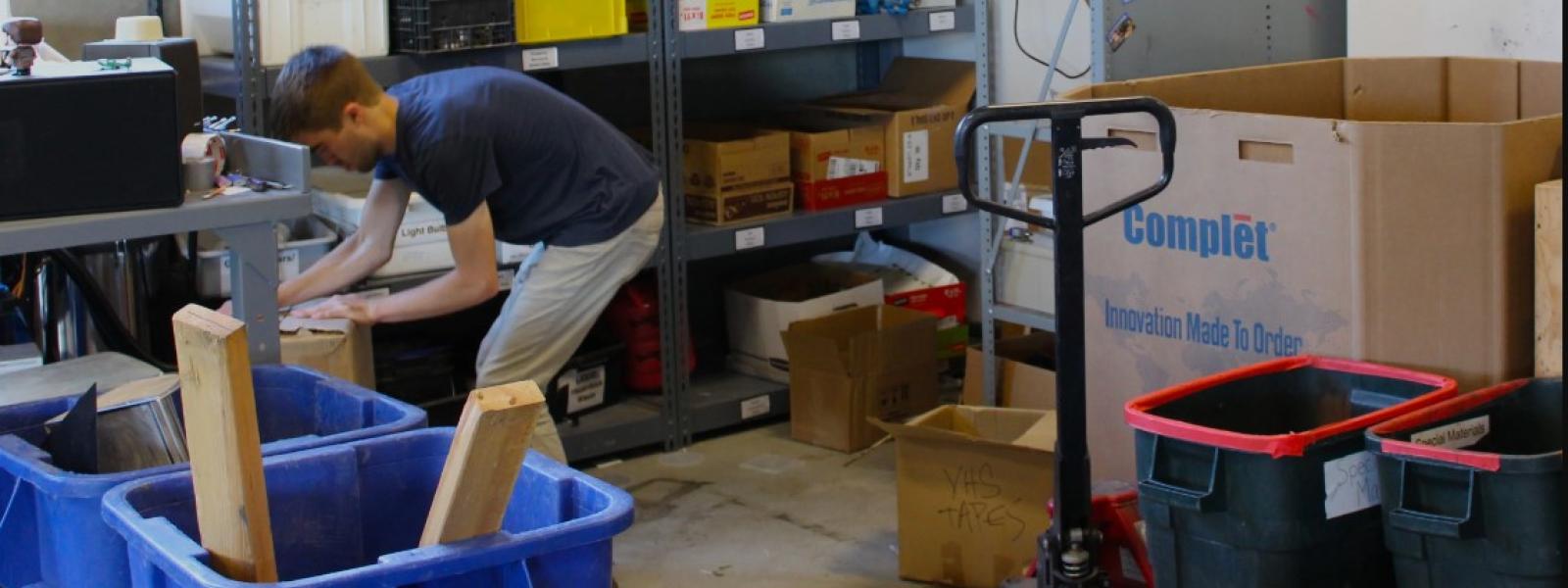 A student worker organizes bins of special materials recycling